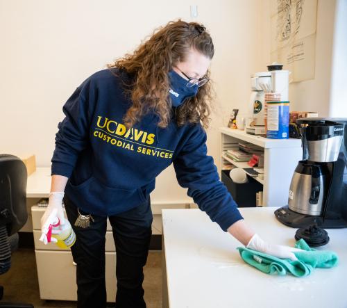 UC Davis custodian sanitizes a campus office space. Staffing the dayshift with more custodians has lead to better response times and improved first impressions in our campus's most heavily trafficked buildings.