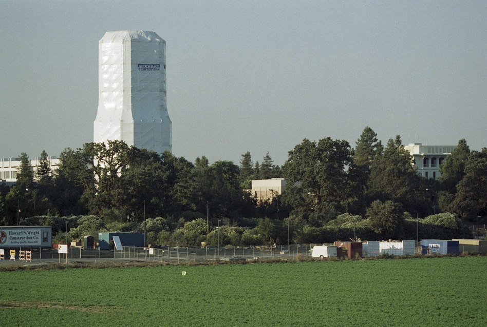 Image of one of UC Davis water tower wrapped with plastic during a repaint.