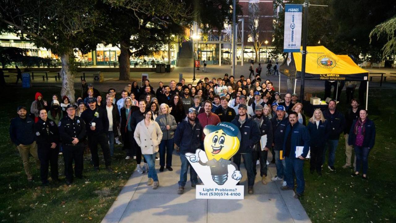 Dozens of people pose for a group photo at a Safety Lighting Walk