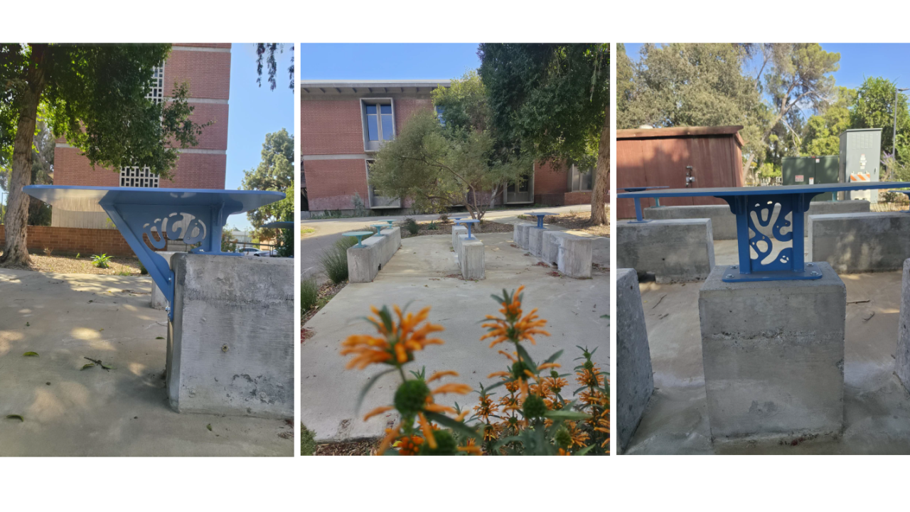 Concrete planter bench with blue metal backrest, white leaf motif and orange flowers