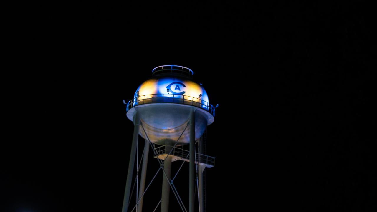 Image of UC Davis' Touchdown Tower at night with the CA logo lit with blue and gold LED lights.