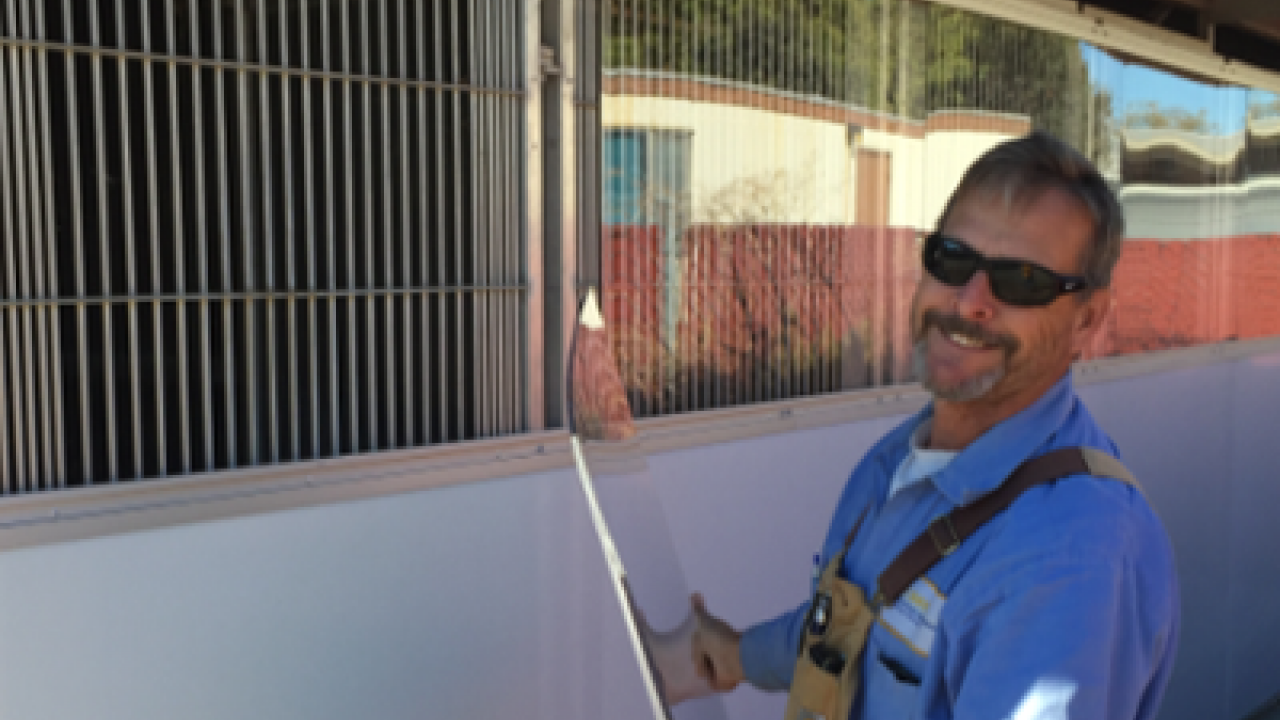 Photo of worker installing plexiglass