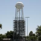 Image of a water tower on the UC Davis campus partially covered in scaffolding.