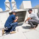 UC Davis staff from the Energy Engingeering team examine air flow on top of Ghausi Hall.