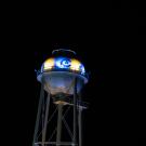 Image of UC Davis' Touchdown Tower at night with the CA logo lit with blue and gold LED lights.