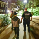 Three people, including a UC Davis police officer participate in a lighting walk