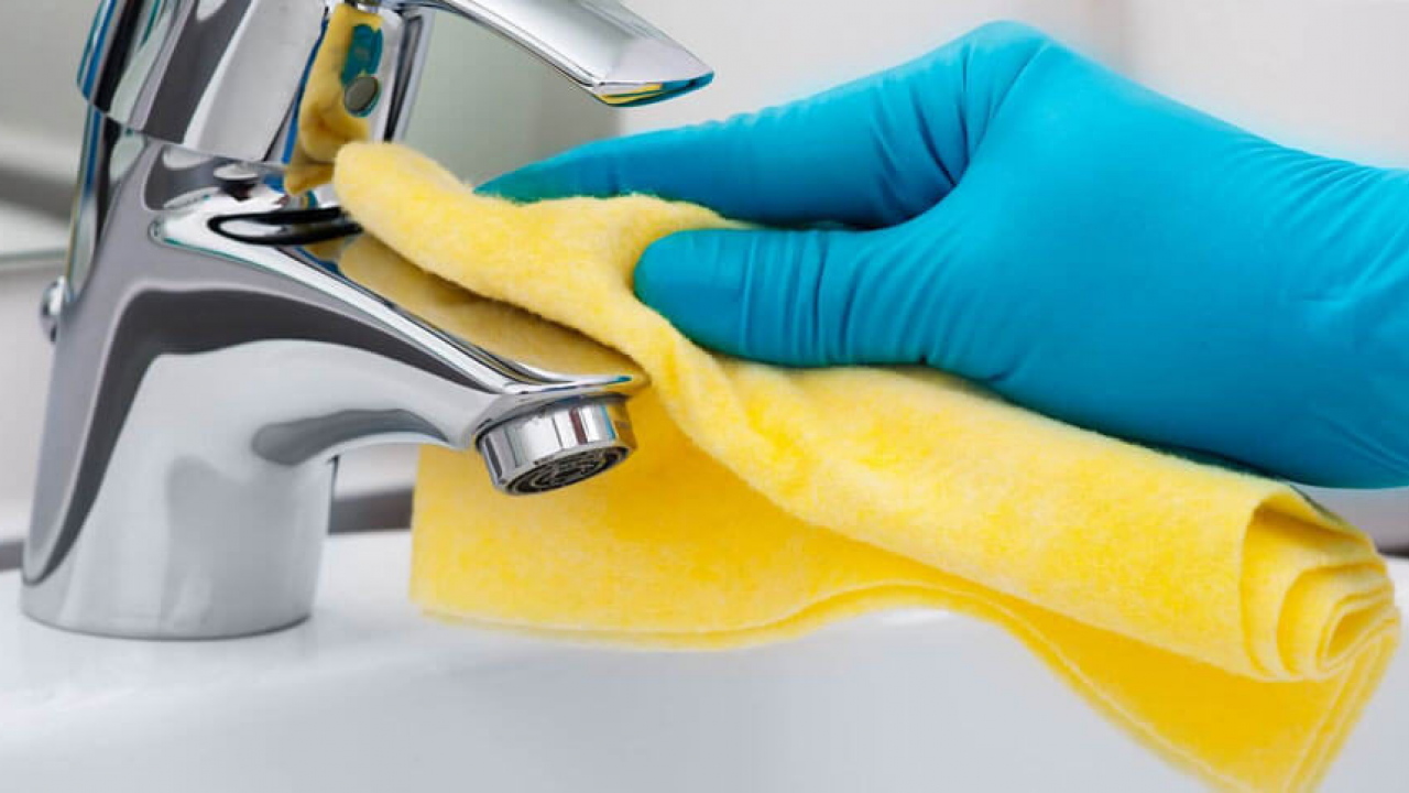 gloved hand washing bathroom sink fixture