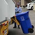 Compost truck lifts recycling bin